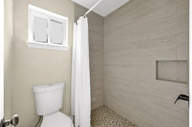 a bathroom with a toilet and a shower