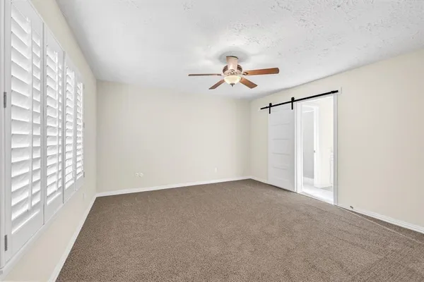 a view of room with a ceiling fan and window