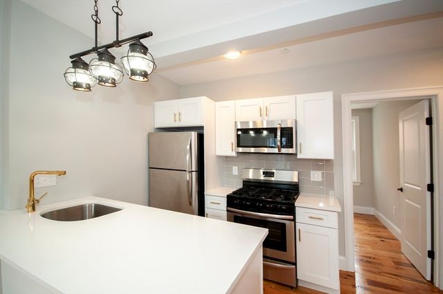 a kitchen with a refrigerator a stove and a sink