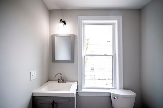 a bathroom with a sink toilet and mirror