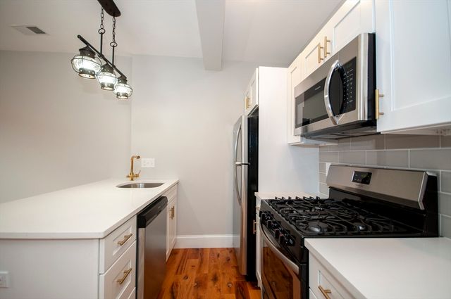 a kitchen with stainless steel appliances a sink a stove and microwave