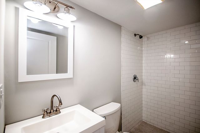 a bathroom with a sink a toilet and a mirror