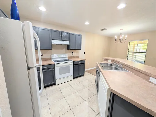 a kitchen with stainless steel appliances a stove a sink and a refrigerator