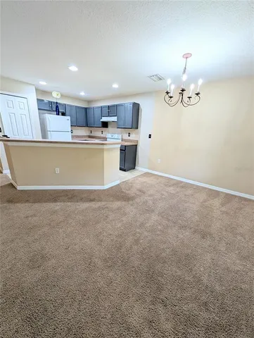 a view of kitchen and kitchen with granite countertop cabinets