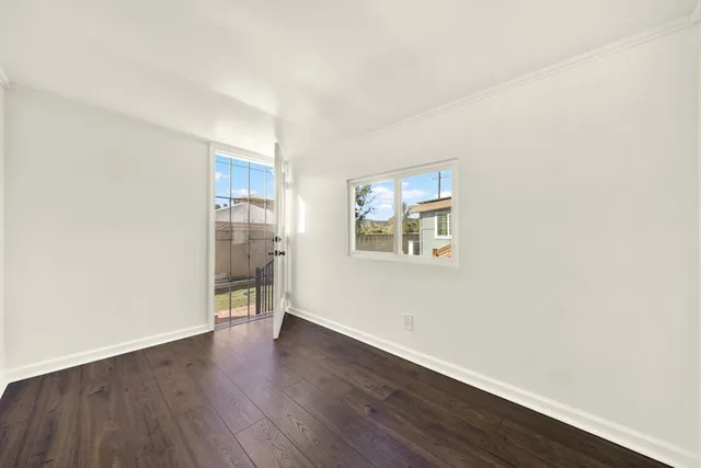 an empty room with wooden floor and a window