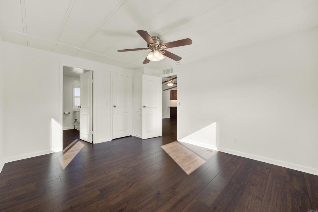 9255 North Magnolia Avenue, Unit SPC 158 Santee, CA 92071 - Photo 22 of 49 an empty room with wooden floor ceiling fan and window