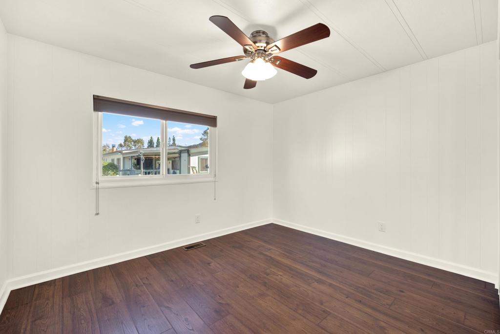 9255 North Magnolia Avenue, Unit SPC 158 Santee, CA 92071 - Photo 33 of 49 an empty room with wooden floor and ceiling fan