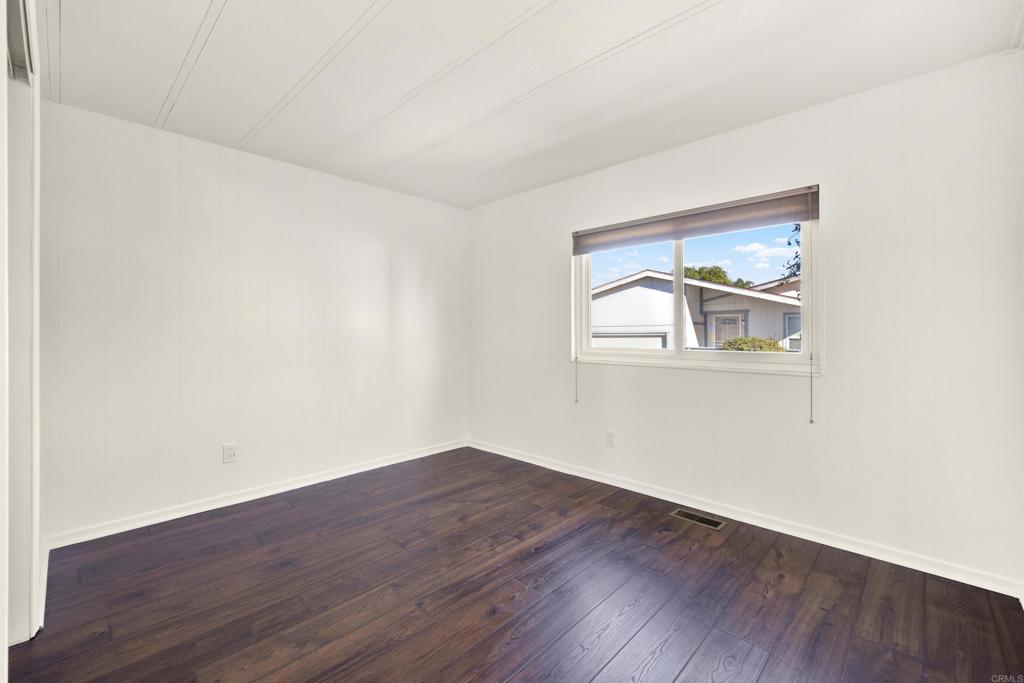 9255 North Magnolia Avenue, Unit SPC 158 Santee, CA 92071 - Photo 36 of 49 an empty room with wooden floor and a window