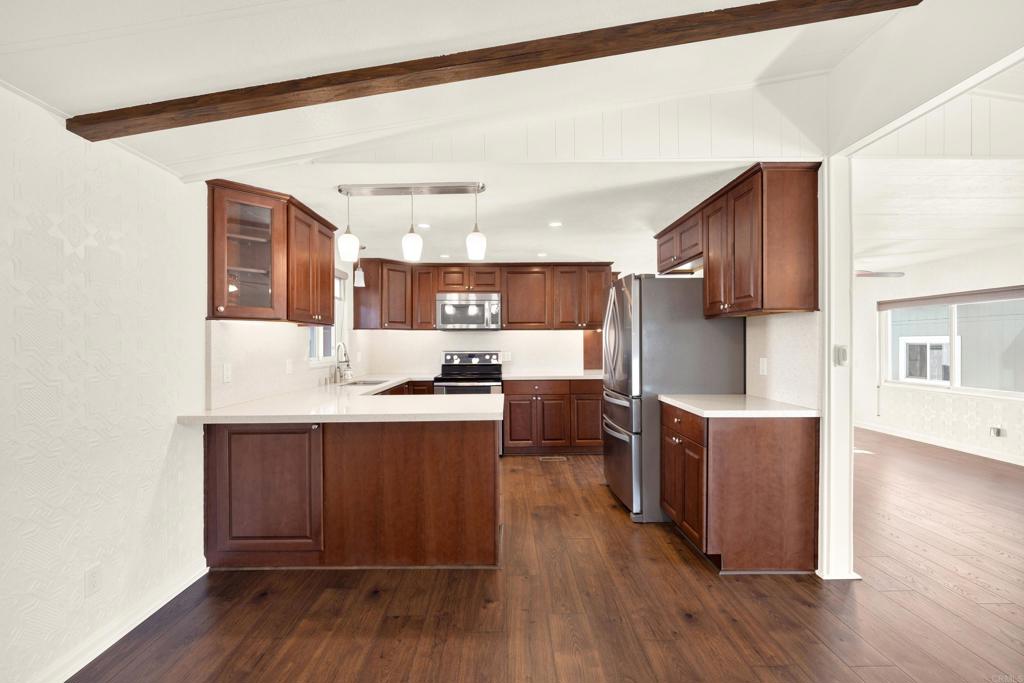 9255 North Magnolia Avenue, Unit SPC 158 Santee, CA 92071 - Photo 6 of 49 a living room with stainless steel appliances kitchen island granite countertop wooden floors and view of living room