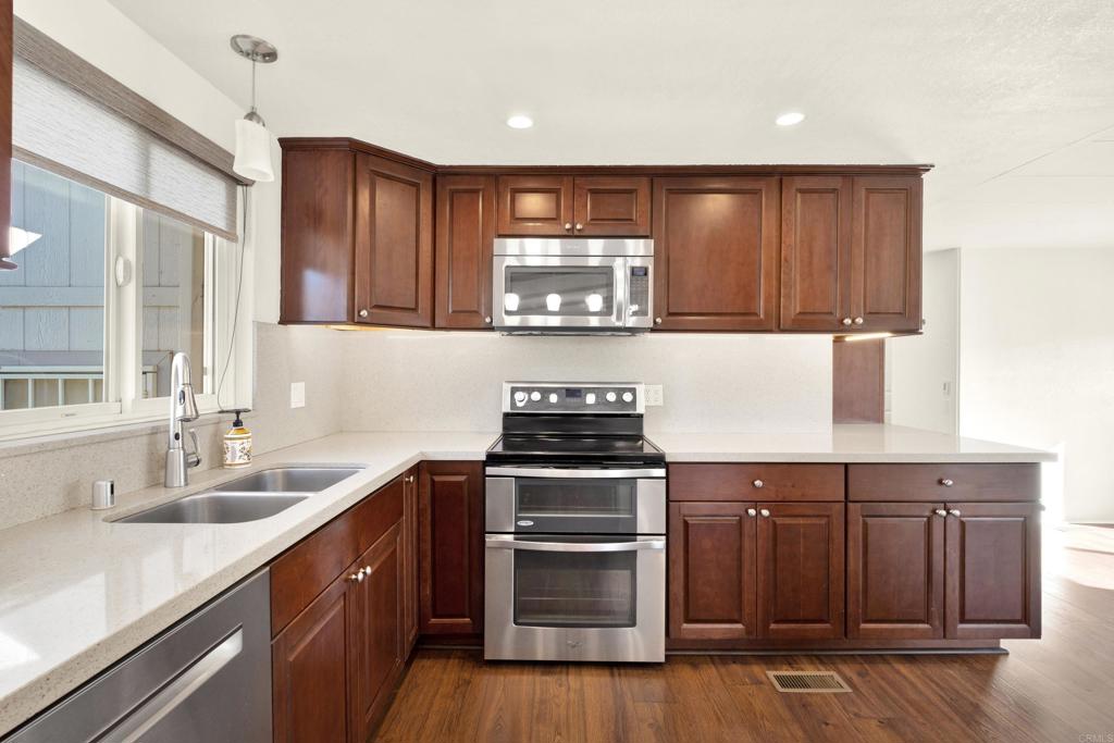 9255 North Magnolia Avenue, Unit SPC 158 Santee, CA 92071 - Photo 8 of 49 a kitchen with stainless steel appliances granite countertop wooden cabinets stove top oven and sink