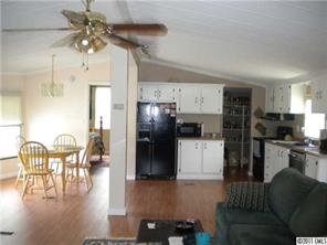 8052 Palm Tree Church Road Vale, NC 28168 - Photo 2 of 10 a kitchen with stainless steel appliances kitchen island granite countertop a refrigerator a stove a microwave oven with a dining table and chairs
