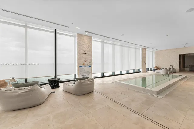 a living room with furniture and large windows