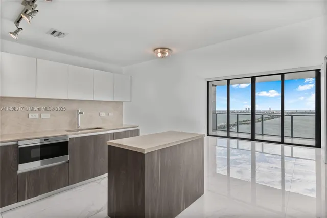 a kitchen with stainless steel appliances a sink stove and cabinets