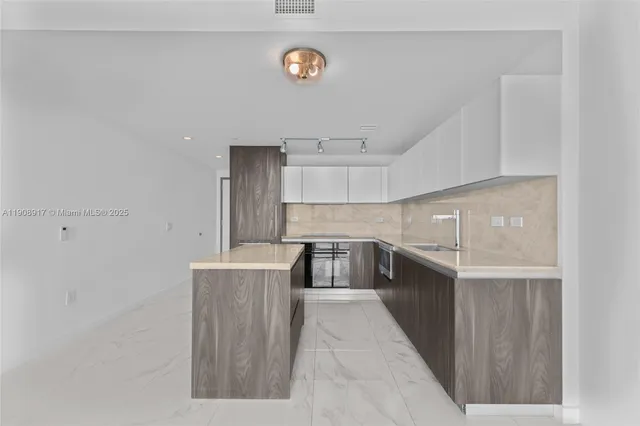 a kitchen with stainless steel appliances granite countertop a refrigerator and a stove