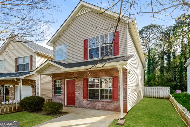 a view of a house with a yard and pathway