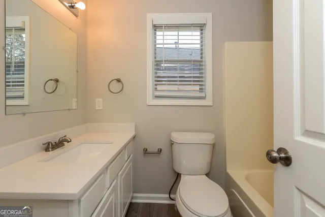 a bathroom with a sink a toilet and mirror