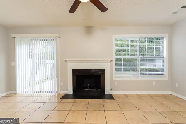 an empty room with windows and fireplace