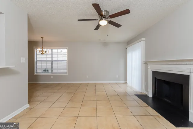 an empty room with windows and fireplace
