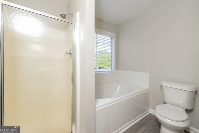 a white toilet sitting next to a bath tub shower