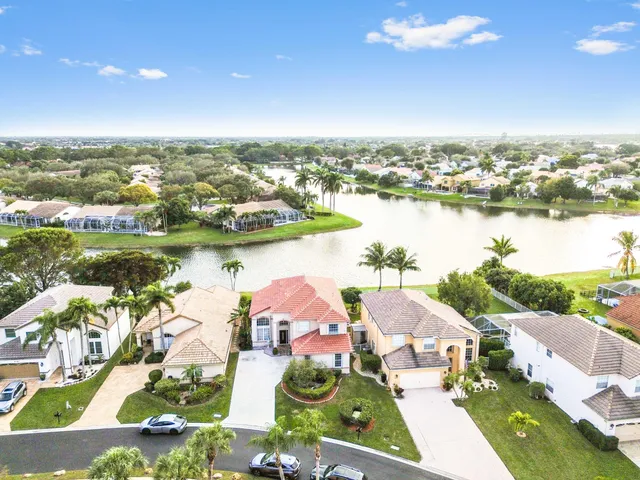 an aerial view of residential houses with outdoor space and lake view