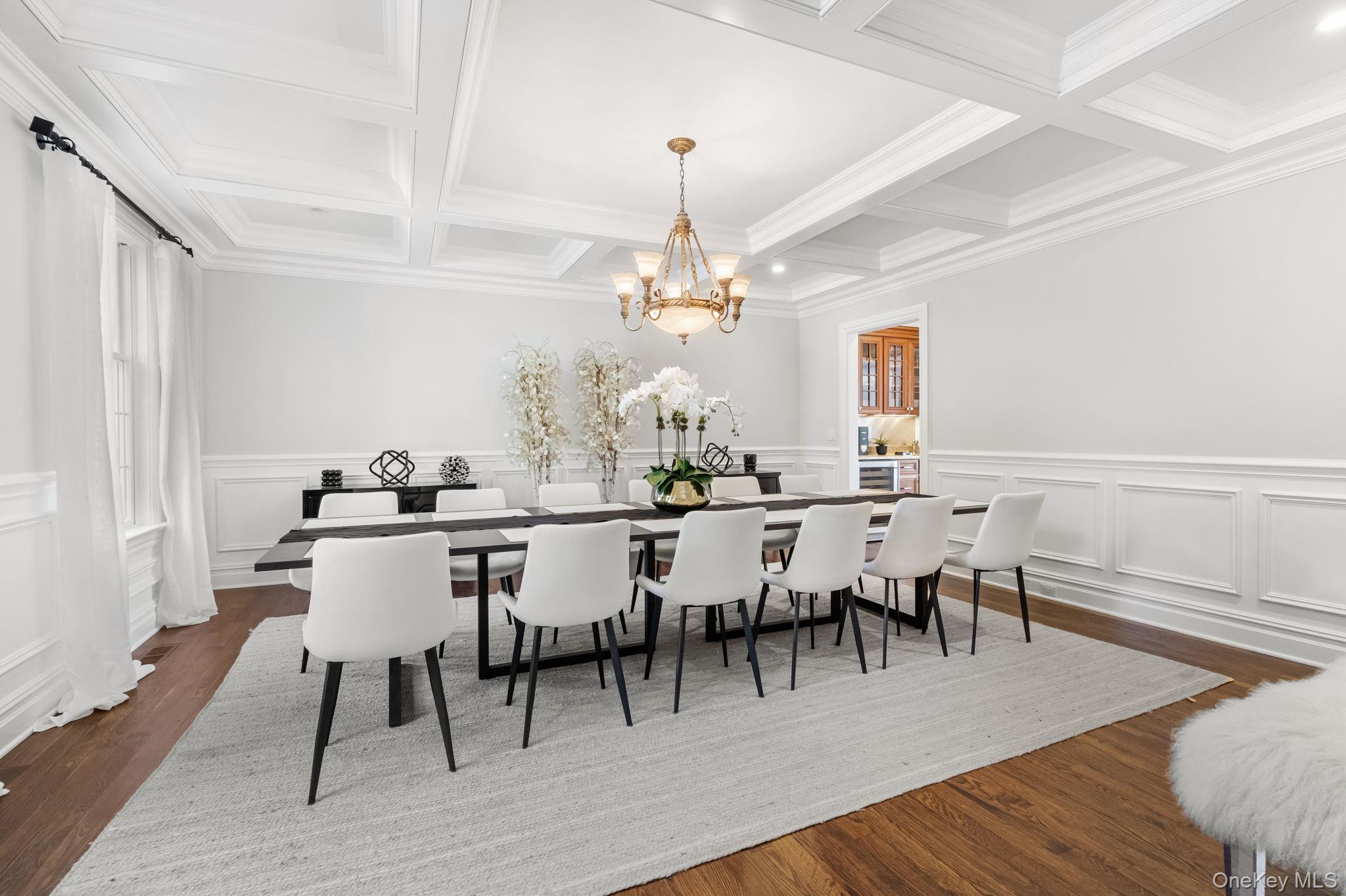 496 Long Ridge Road Bedford, NY 10576 - Photo 9 of 49 Dining area featuring beam ceiling, dark wood-style floors, a chandelier, a decorative wall, and coffered ceiling