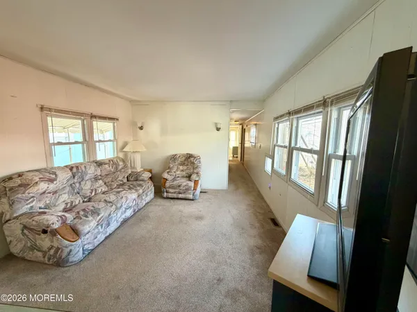 a spacious bedroom with a bed lamp and a large window