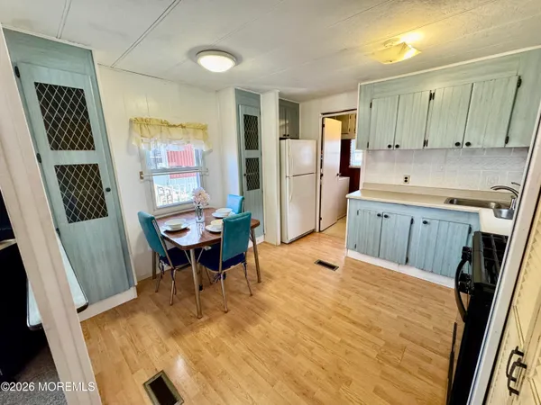 a kitchen with a table chairs refrigerator and a sink