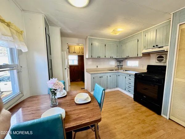 a kitchen with stainless steel appliances granite countertop a stove a sink dishwasher and cabinets with wooden floor