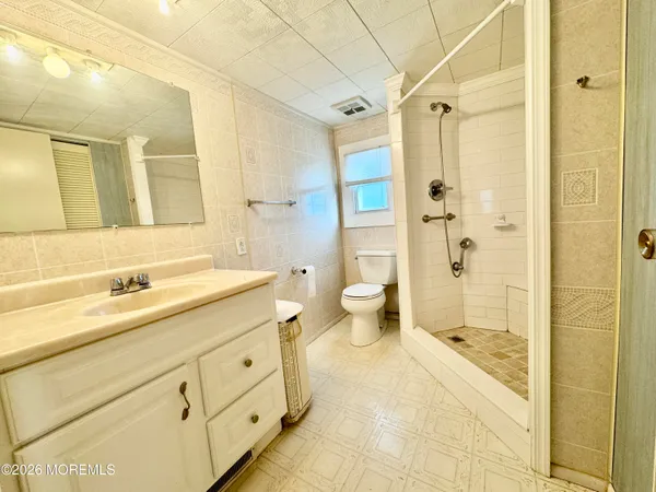 a spacious bathroom with a shower sink and mirror