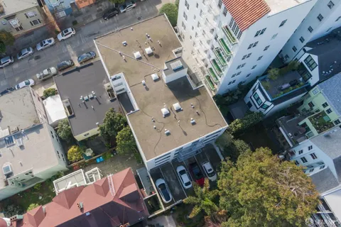 an aerial view of residential houses with outdoor space and parking