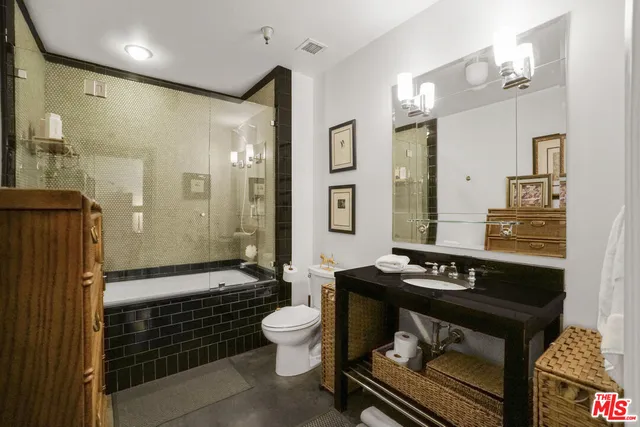 a bathroom with a sink a toilet a mirror and shower