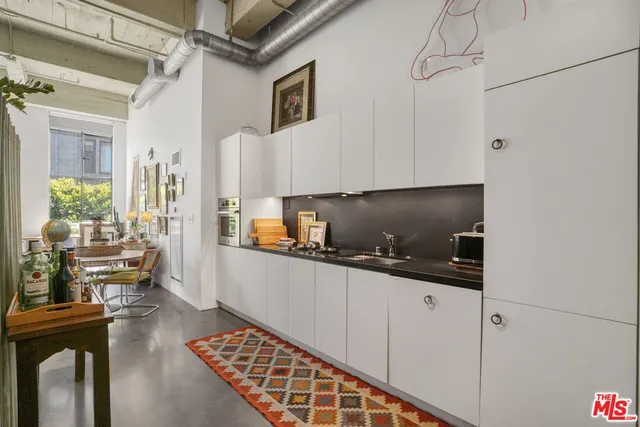 a kitchen with granite countertop a sink a stove and cabinets