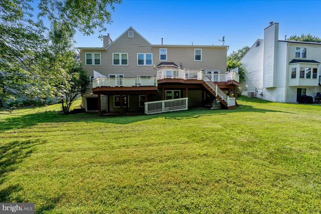 a view of a house with a big yard and large trees
