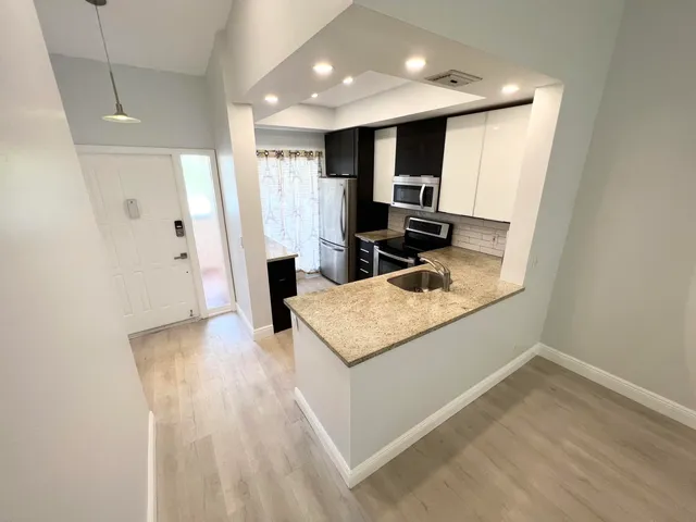 a kitchen with stainless steel appliances granite countertop a sink refrigerator and microwave