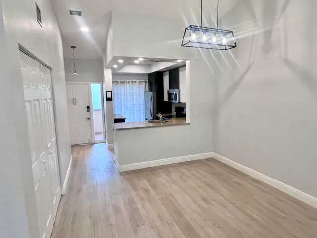 a view of a room with wooden floor and chandelier