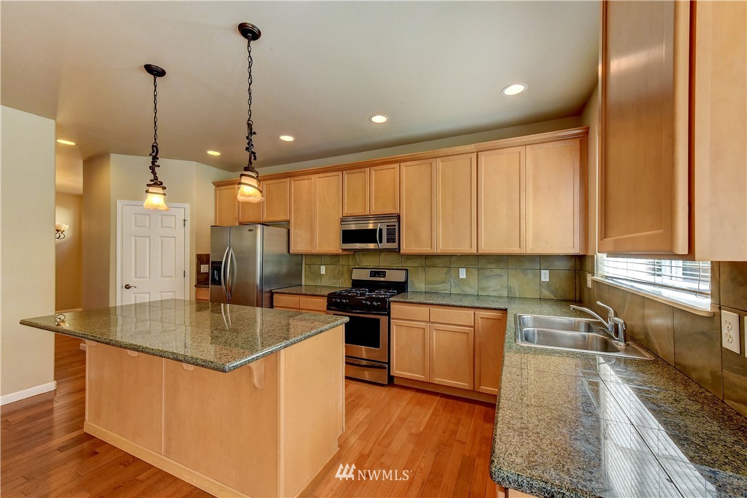 1716 235th Place Southwest Bothell, WA 98021 - Photo 8 of 25 a kitchen with stainless steel appliances granite countertop a sink a stove and a refrigerator