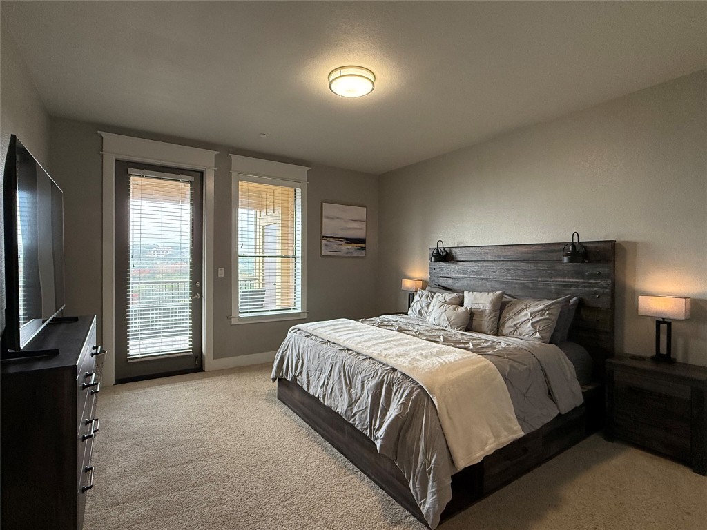17808 Maritime Point, Unit 301 Jonestown, TX 78645 - Photo 11 of 40 a bedroom with a bed and a flat tv screen on the dresser