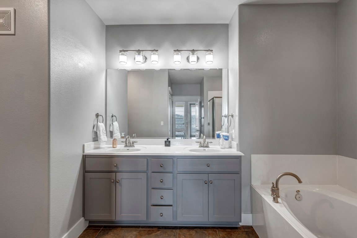 17808 Maritime Point, Unit 301 Jonestown, TX 78645 - Photo 13 of 40 a bathroom with a sink double vanity granite tub and a mirror