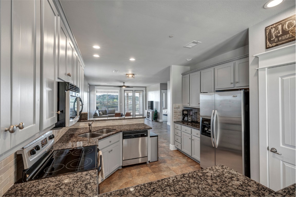 17808 Maritime Point, Unit 301 Jonestown, TX 78645 - Photo 4 of 40 a kitchen with stainless steel appliances granite countertop a stove a sink and a refrigerator