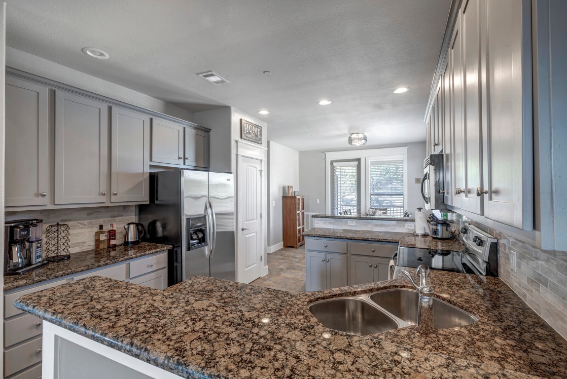 17808 Maritime Point, Unit 301 Jonestown, TX 78645 - Photo 5 of 40 a kitchen with stainless steel appliances granite countertop a sink stove and refrigerator