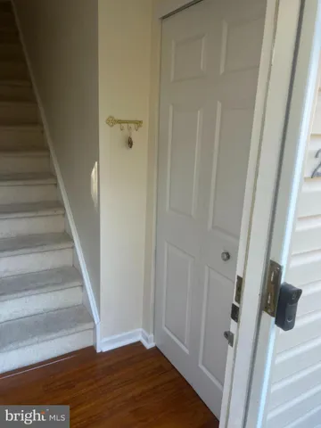 a view of staircase with white walls and white door