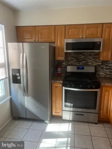 a kitchen with granite countertop a refrigerator and a stove