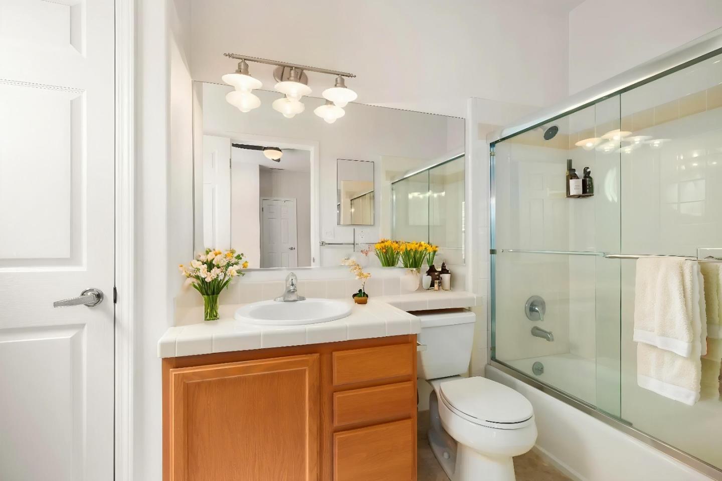 551 Merritt Avenue, Unit 1 Oakland, CA 94610 - Photo 13 of 20 a bathroom with a granite countertop sink toilet a mirror a vanity and shower