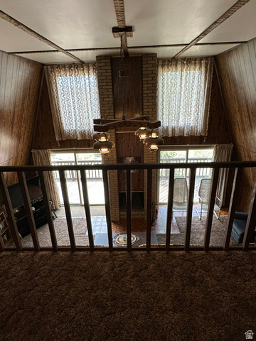 1085 West Elk Road Helper, UT 84526 - Photo 24 of 40 A-frame interior featuring a prominent brick fireplace with a wood mantle, vaulted ceilings with exposed beams, and wood-paneled walls