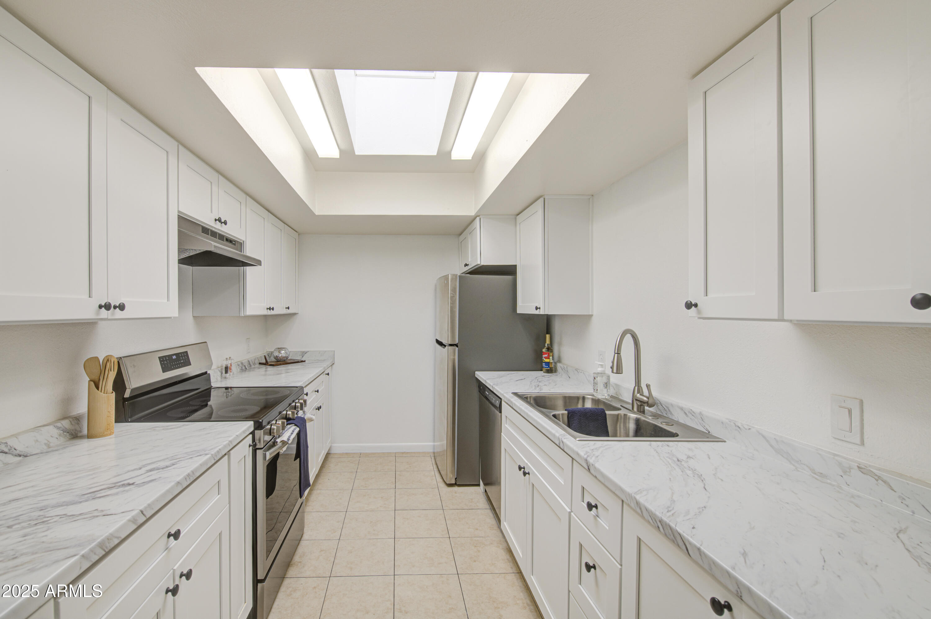 a kitchen with stainless steel appliances sink refrigerator and cabinets