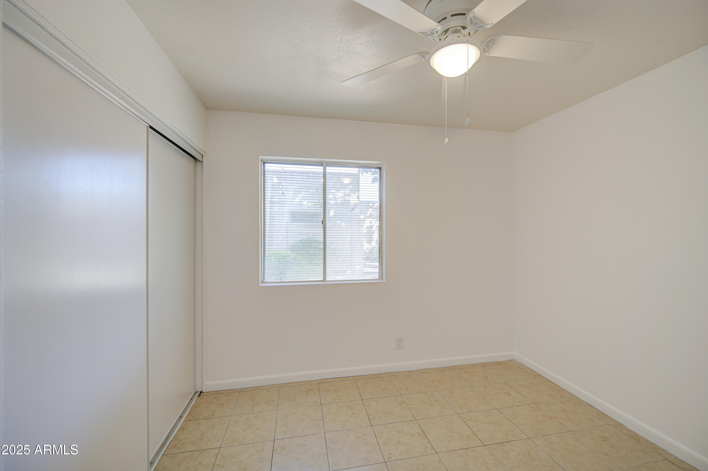 712 South Lebanon Lane Tempe, AZ 85288 - Photo 19 of 35 an empty room with a window and a fan