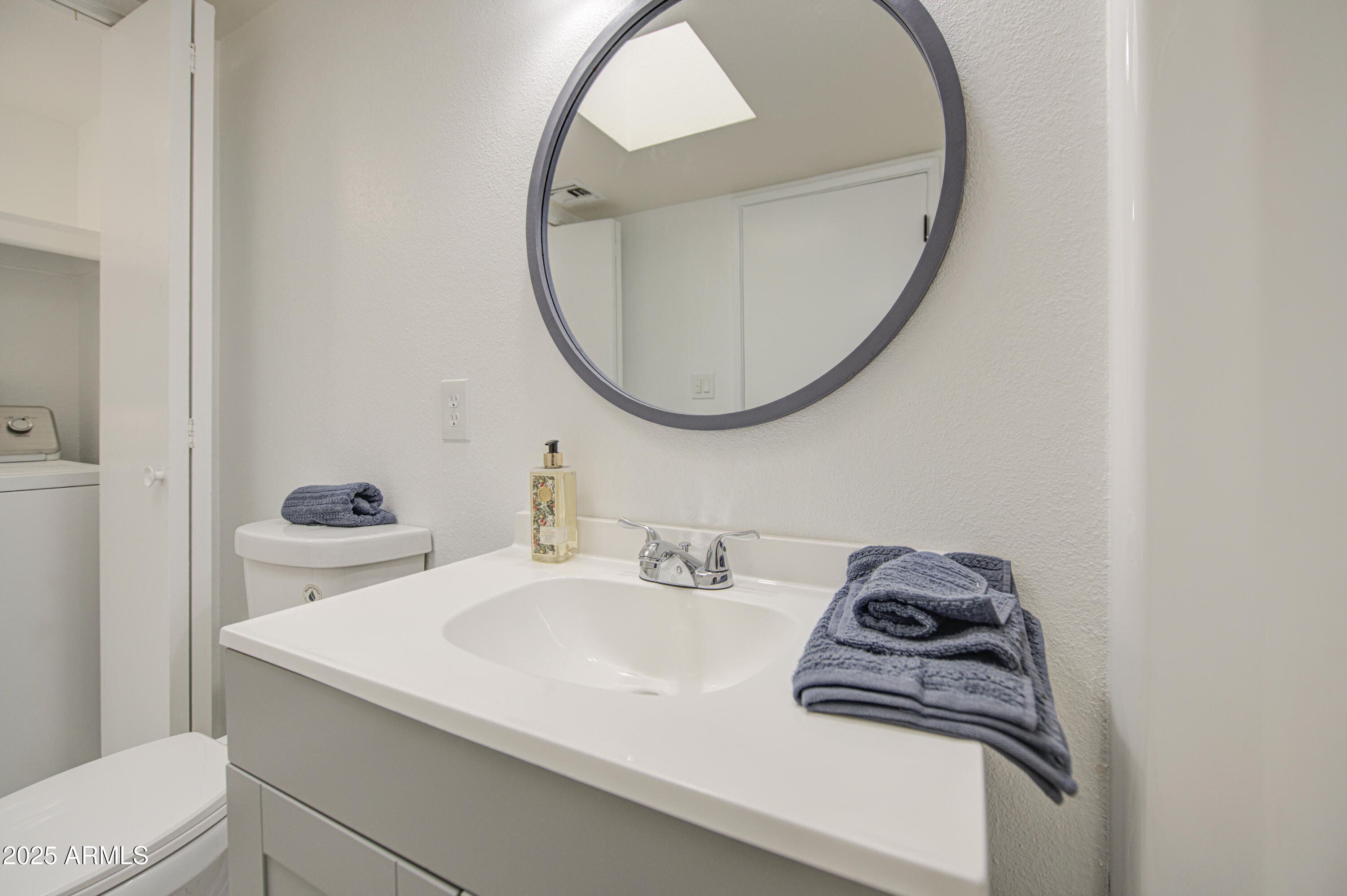 712 South Lebanon Lane Tempe, AZ 85288 - Photo 21 of 35 a bathroom with a sink a mirror and a toilet