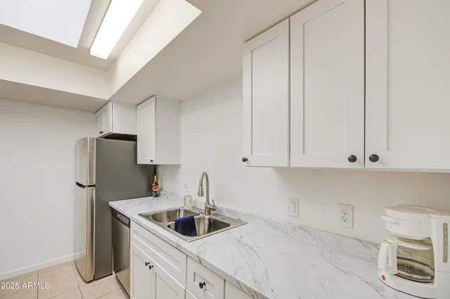 a kitchen with stainless steel appliances granite countertop a sink and a white cabinets