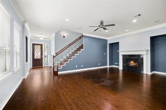 a view of a livingroom with wooden floor and a fireplace