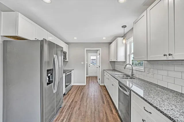 a kitchen with stainless steel appliances granite countertop a sink stove and refrigerator